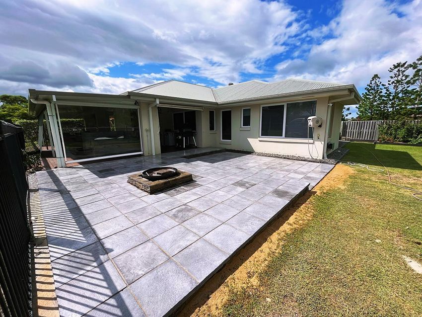 A House with a Patio and a Fire Pit in Front of It — HMJ Landscapes in Broadbeach, QLD