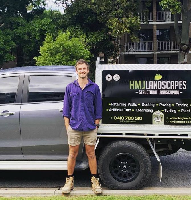 A Man Standing Next to a Truck That Says HM Landscapes — HMJ Landscapes in Broadbeach, QLD
