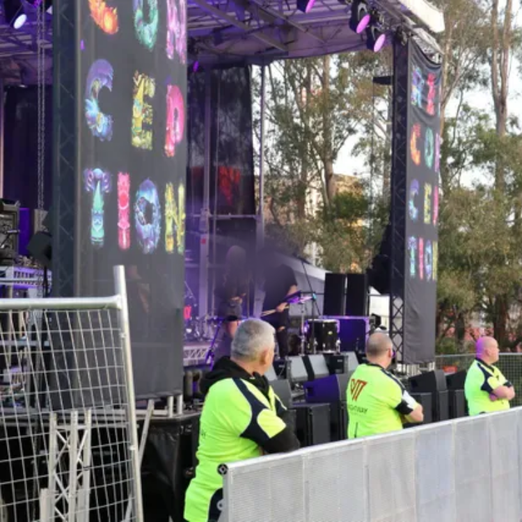 A group of people standing in front of a stage that says creation
