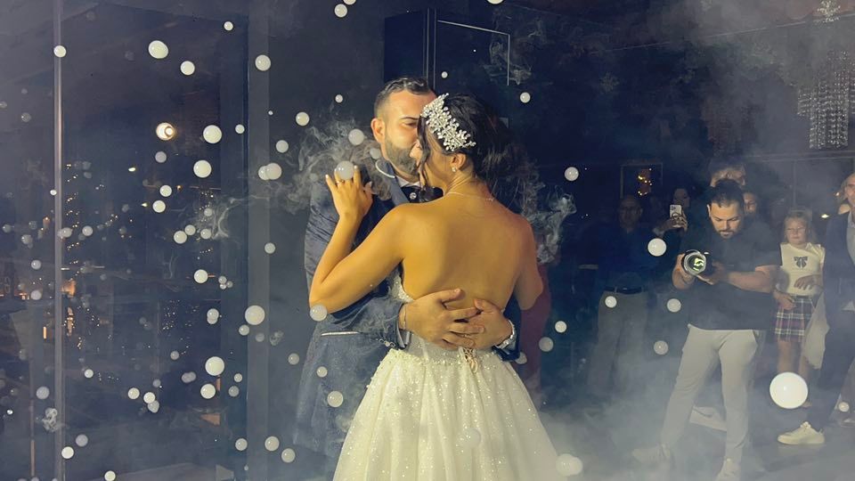 Gli sposi si baciano vicino a una torta nuziale a più piani a 