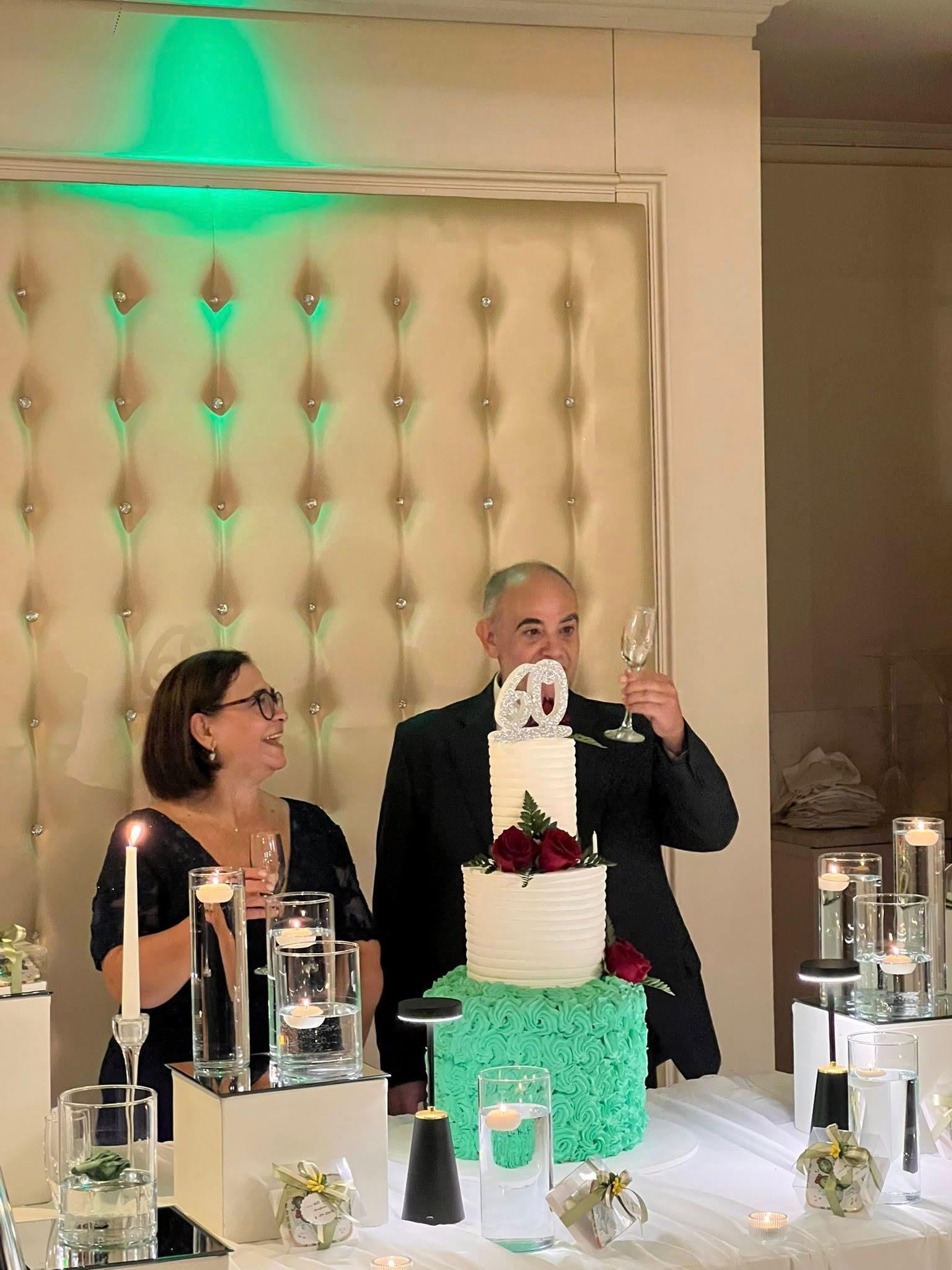 Coppia che brinda vicino a una torta a più piani con la scritta