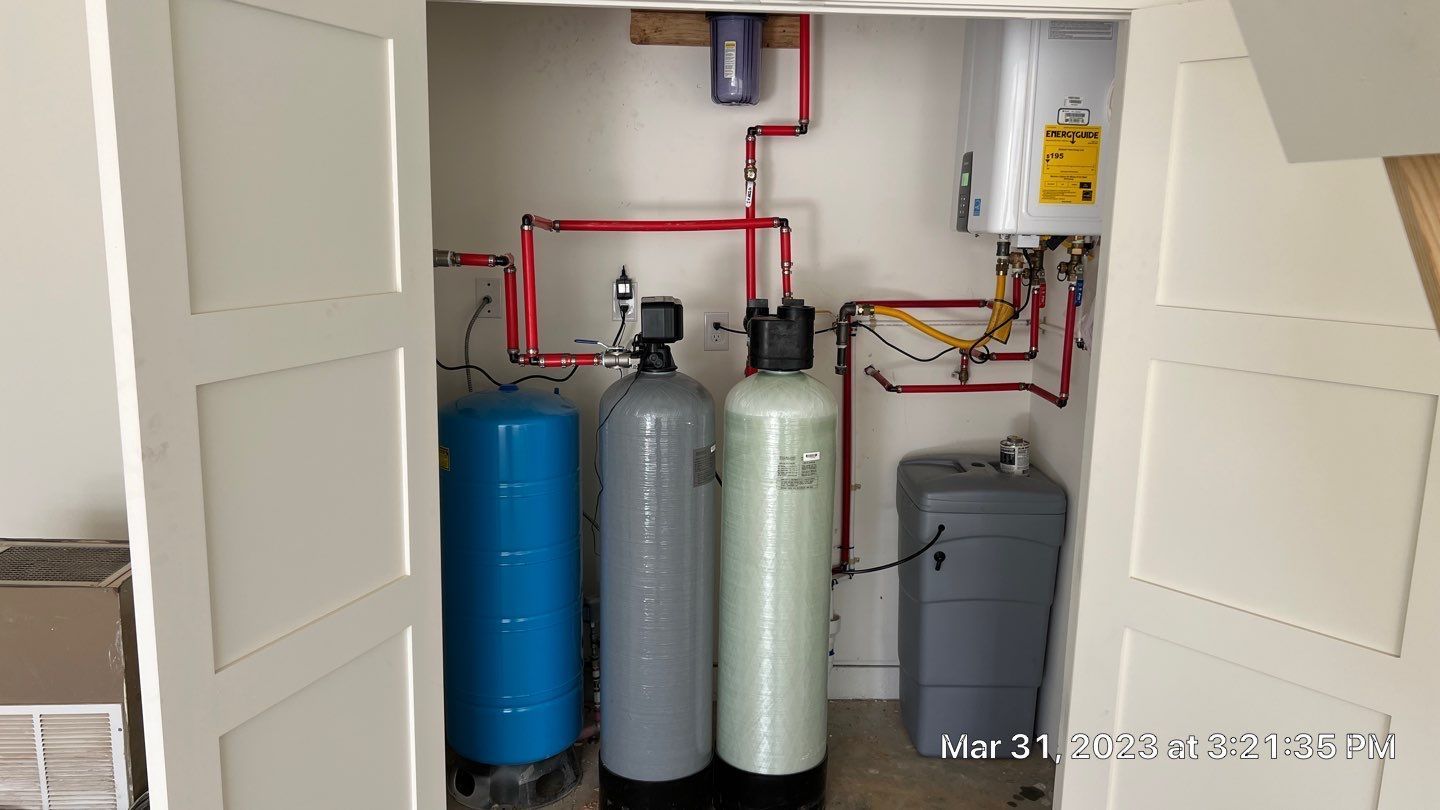 A closet filled with water tanks and pipes