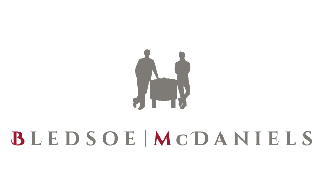 Bledsoe McDaniels logo with two gray figures beside a table above the firm name