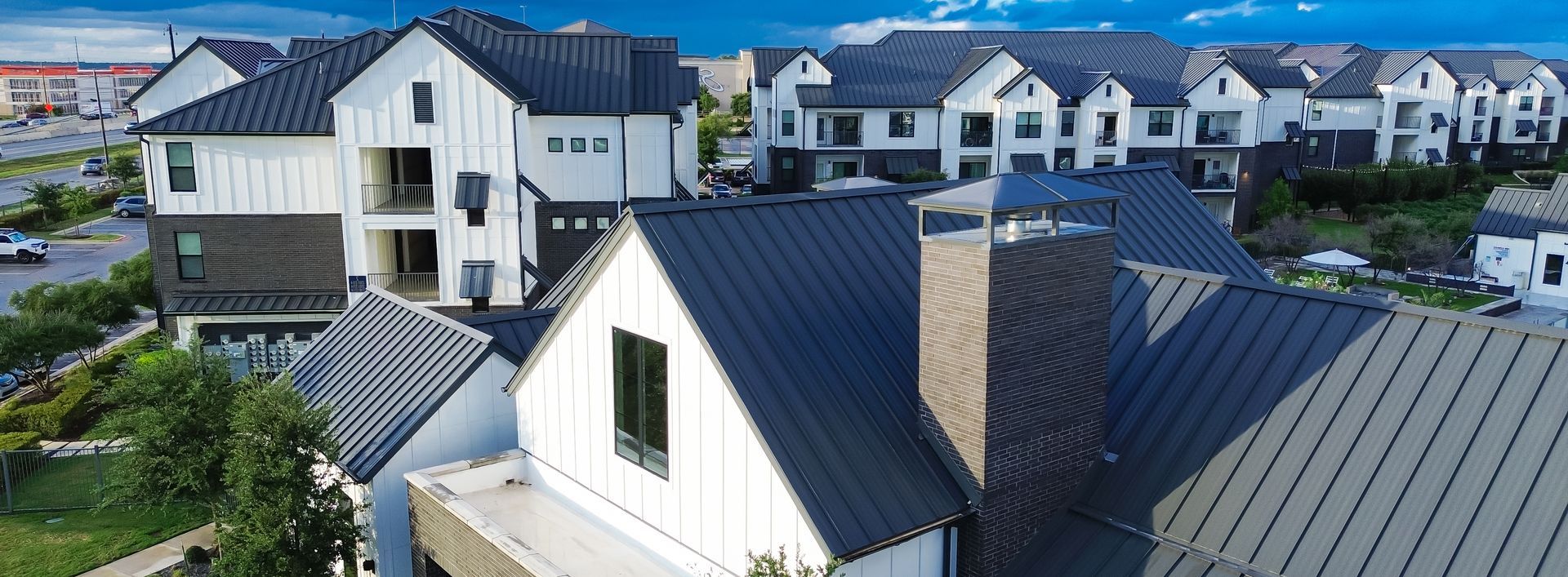 An aerial view of a row of houses with black roofs.