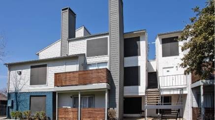 A large apartment building with a lot of windows and chimneys.
