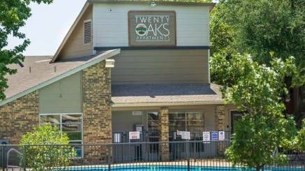 A large apartment building with a swimming pool in front of it.