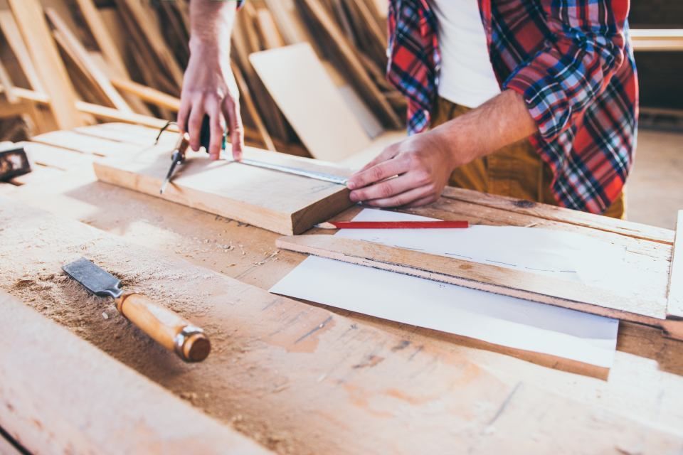 carpenter constructing and measuring wood