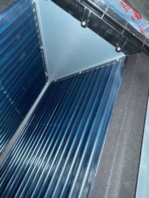 Blue ribbed metal panels meeting at a gray triangular corner, likely an interior industrial surface.