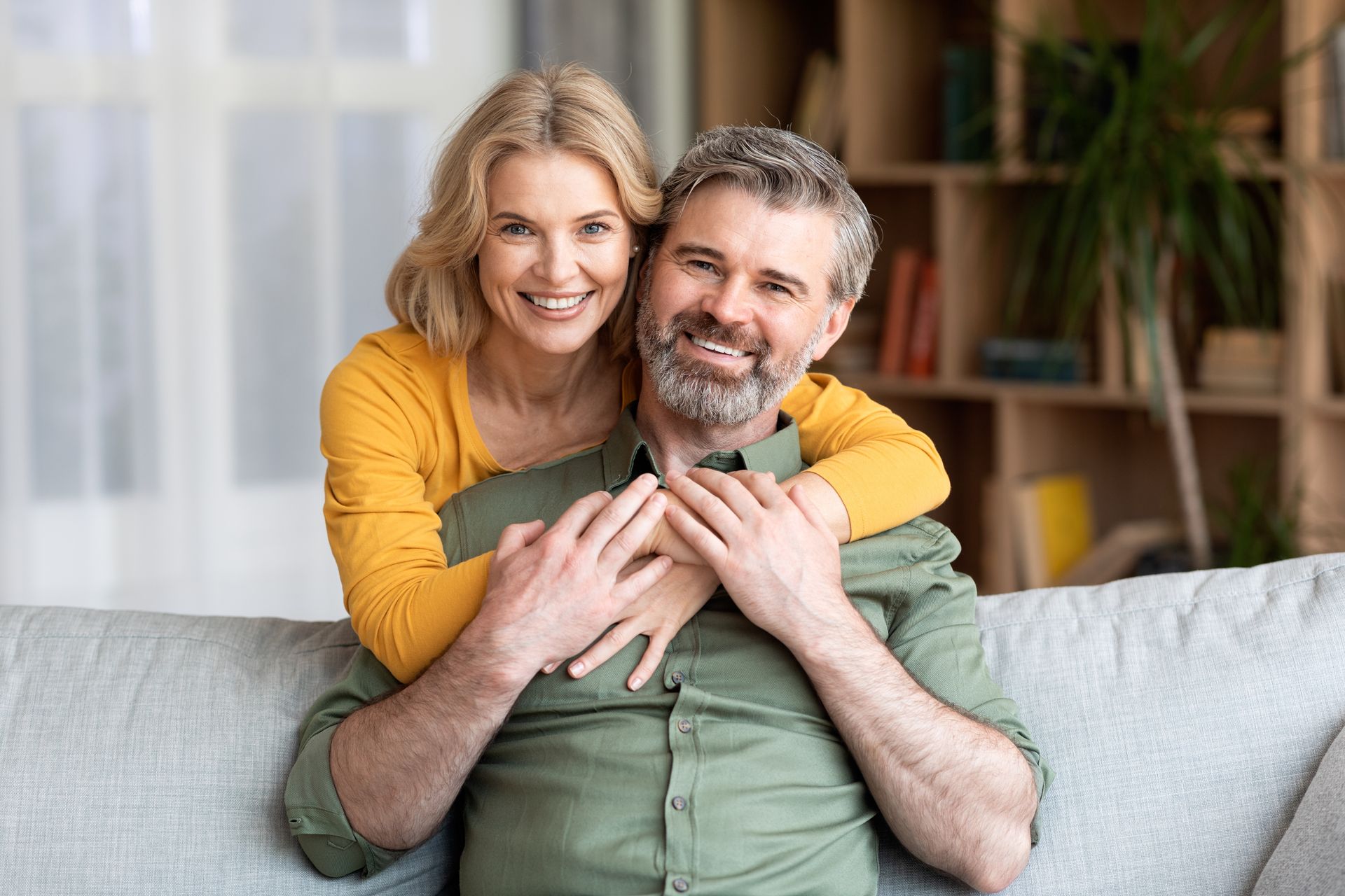 women looking into mirror after getting dental implants