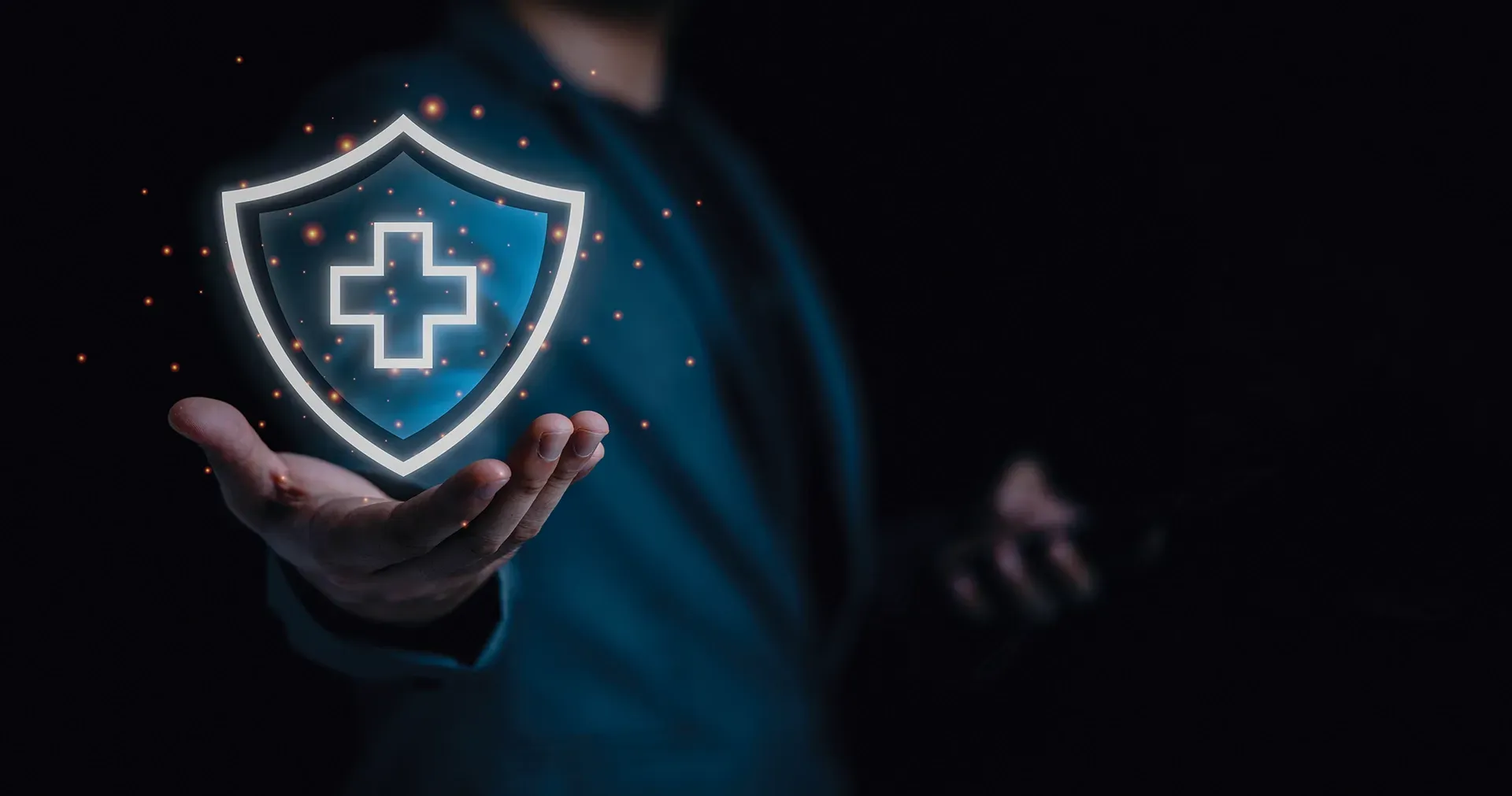 Person holding a glowing shield with a medical cross, symbolizing healthcare security.