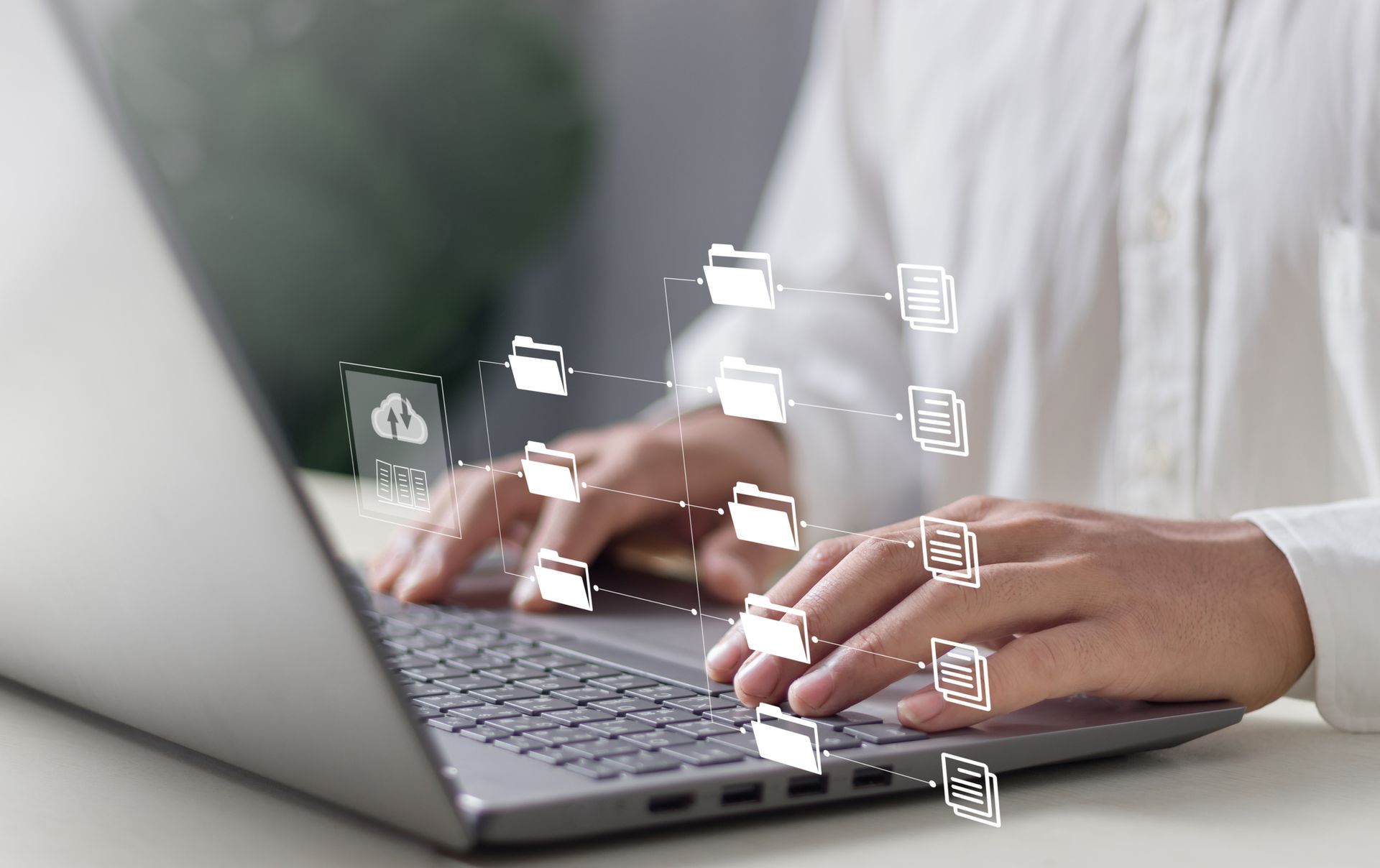 Person typing on laptop, connected to cloud and digital file icons.