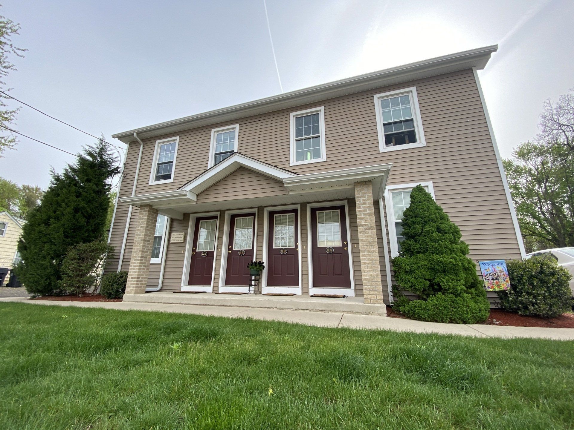 Large house with grass and shrub in front of it — Vernon, CT — A1 Properties