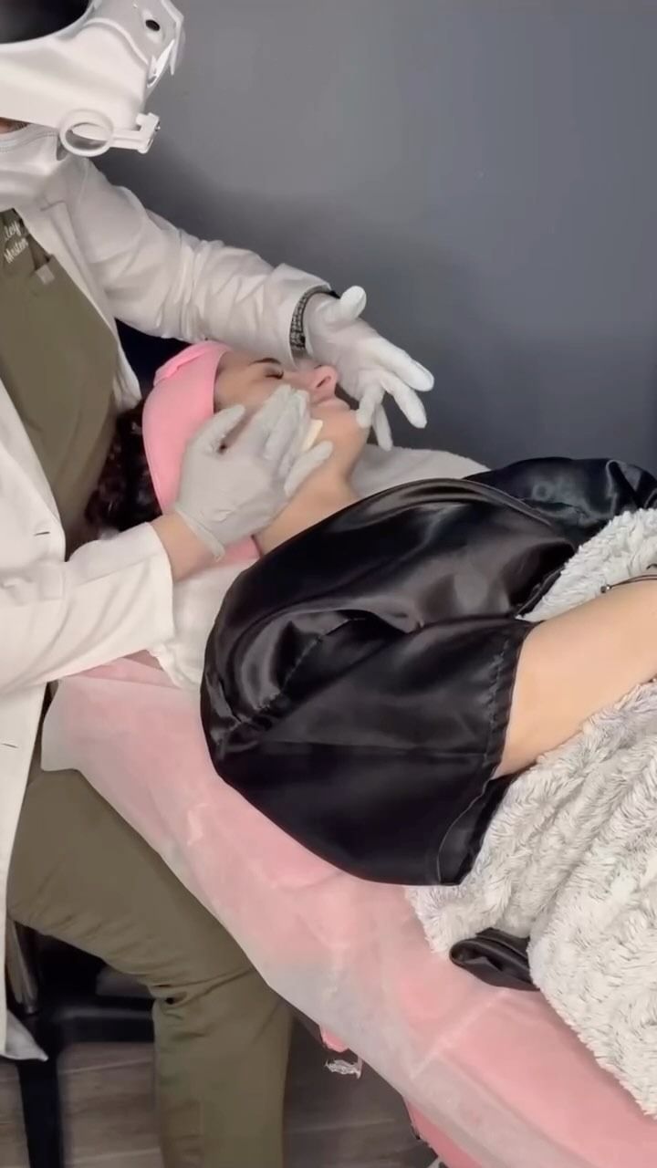 Person getting a facial at a spa. The person is lying down, while another is attending to their face.
