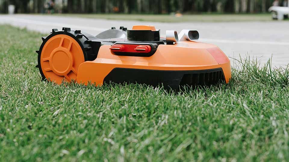 Robotic Lawn Mower Trimming The Edge Of Sidewalk