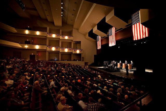House of Worship AV soltuions. Concert stage with band, vertical lights, snowflakes, and audience; blue and white lighting.