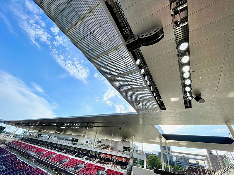 Stadium AV soltuions. Stadium roof with lights, partial view of red seats and blue sky.