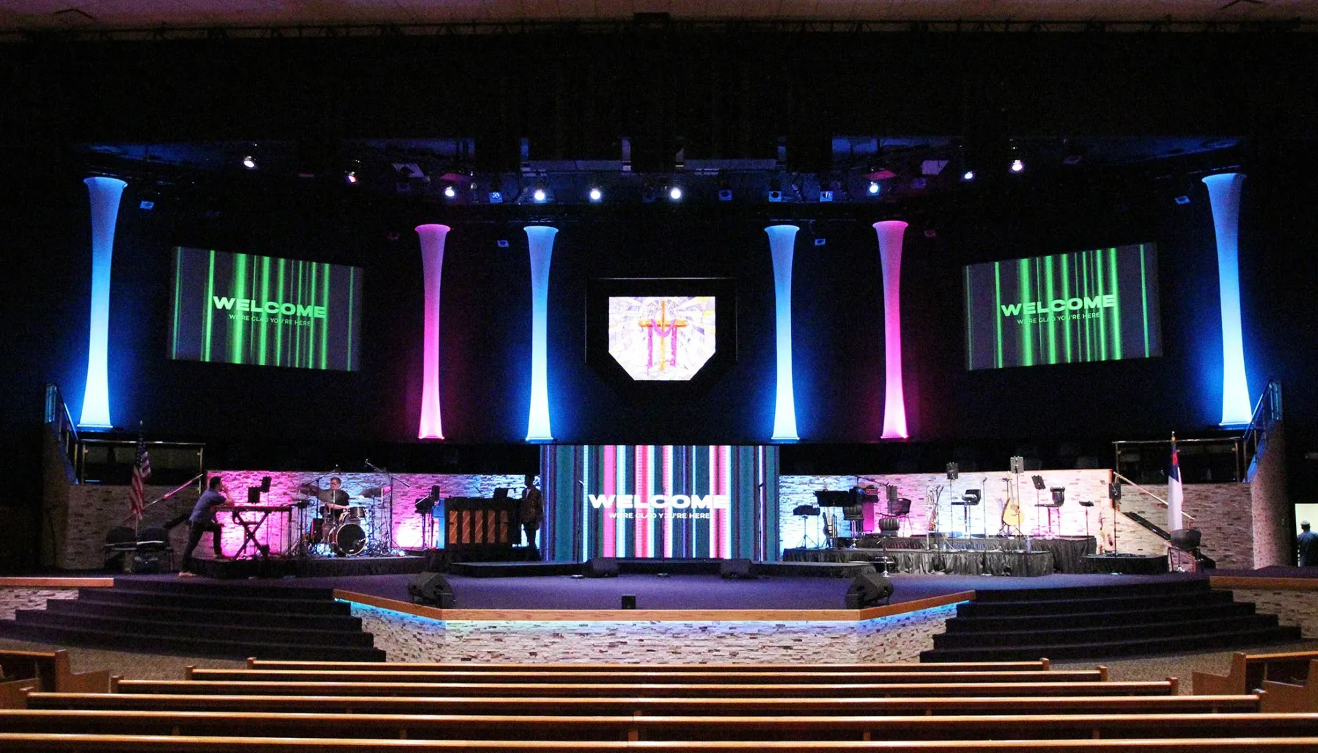 House of Worship AV solutions. Stage with colorful lighting and screens in a church setting.