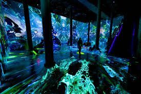 Auditorium AV solutions. An empty auditorium with rows of maroon seats, balconies, and a stage in soft lighting.