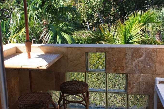 A balcony with a table and chairs and a view of trees