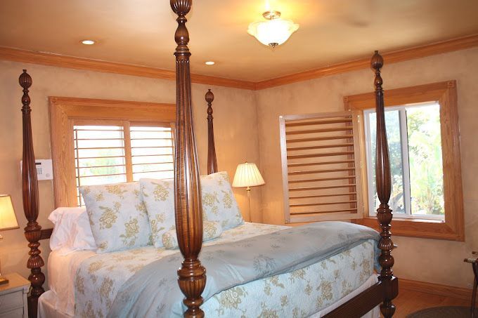 A bedroom with a four poster bed and a window
