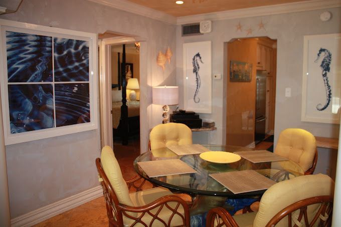 A dining room with a glass table and chairs