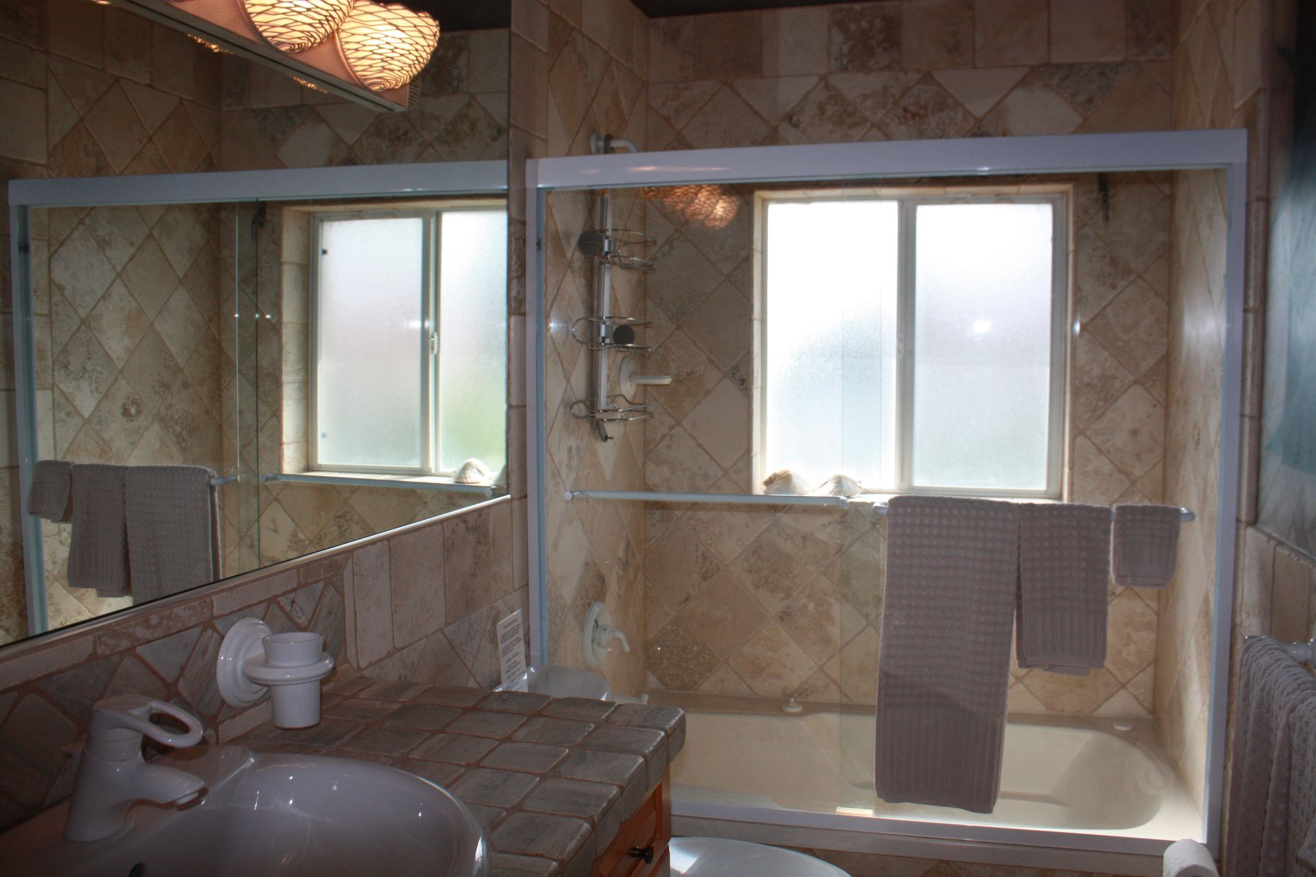 A bathroom with a sink a tub and a window