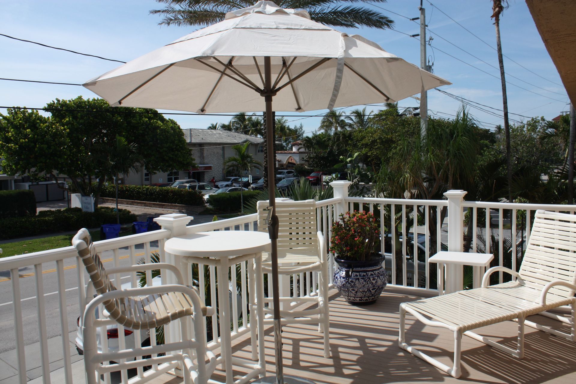A balcony with a table and chairs and an umbrella