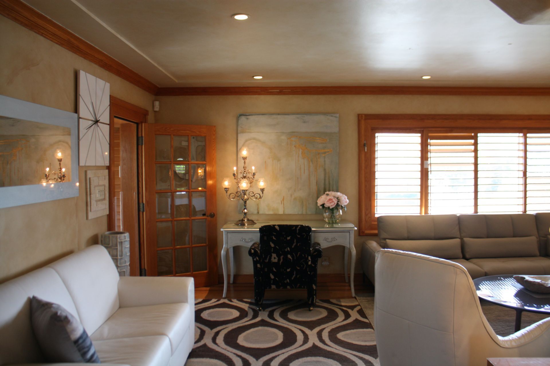 A living room with a couch , chair , table and mirror.