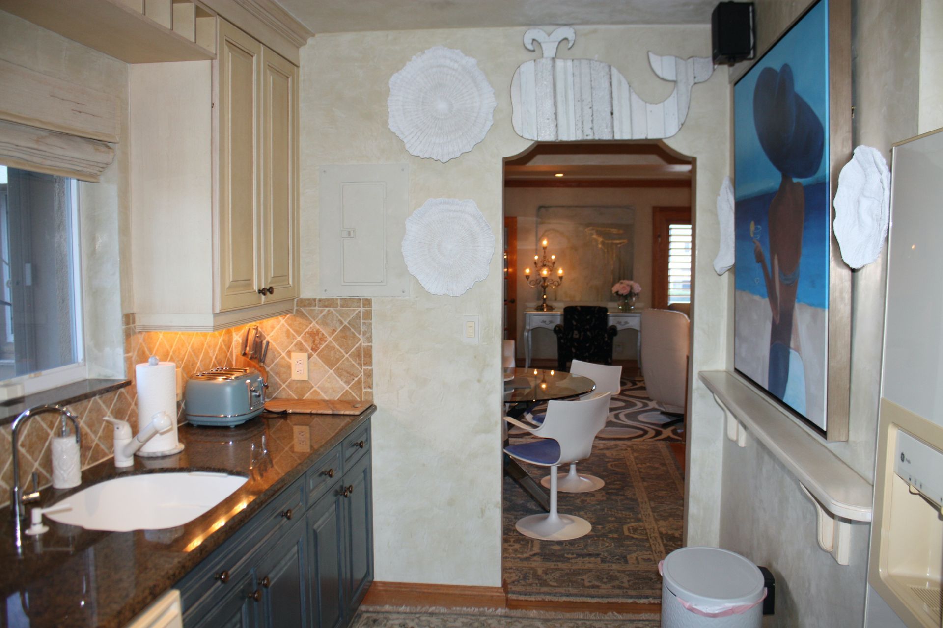 A kitchen with a sink and a painting on the wall
