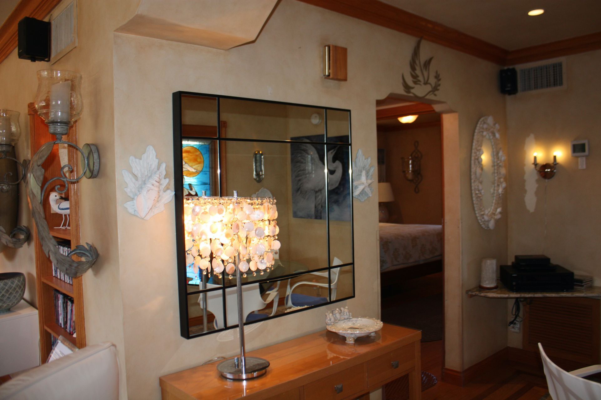 A living room with a large mirror and a lamp on a table