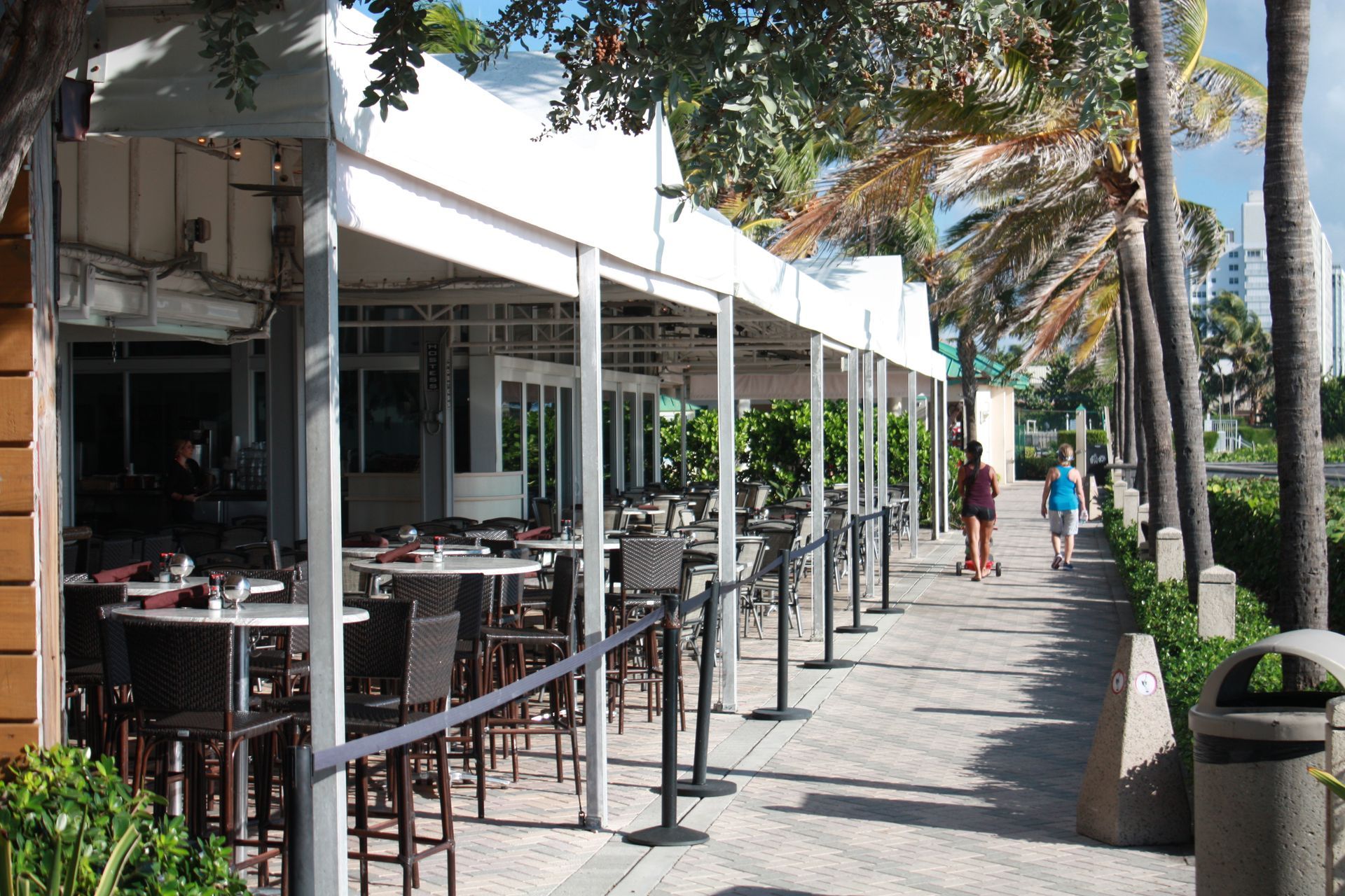 A row of tables and chairs outside of a restaurant