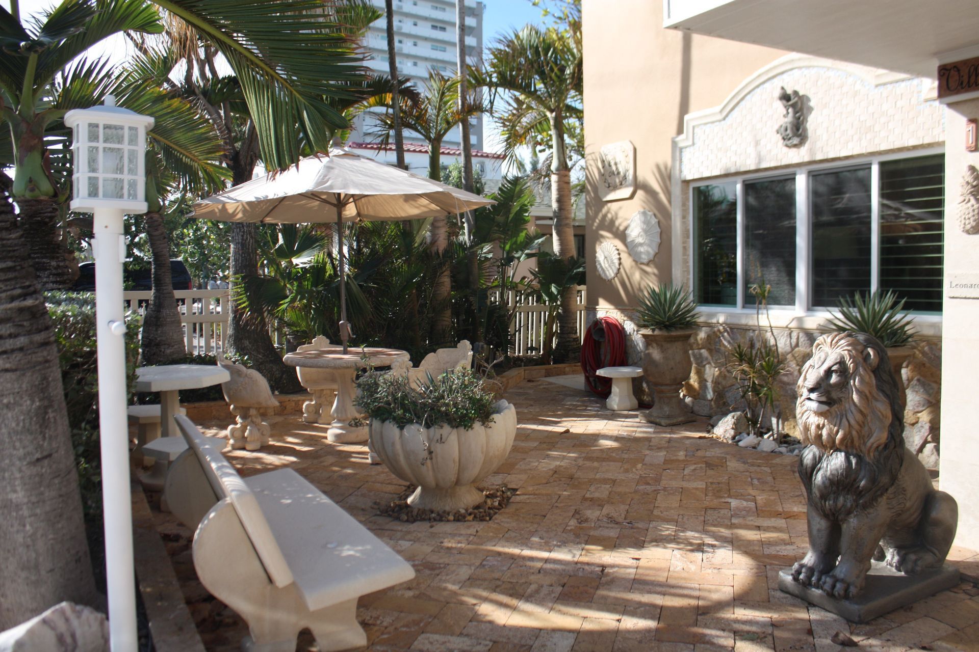 A patio with a statue of a lion and a bench
