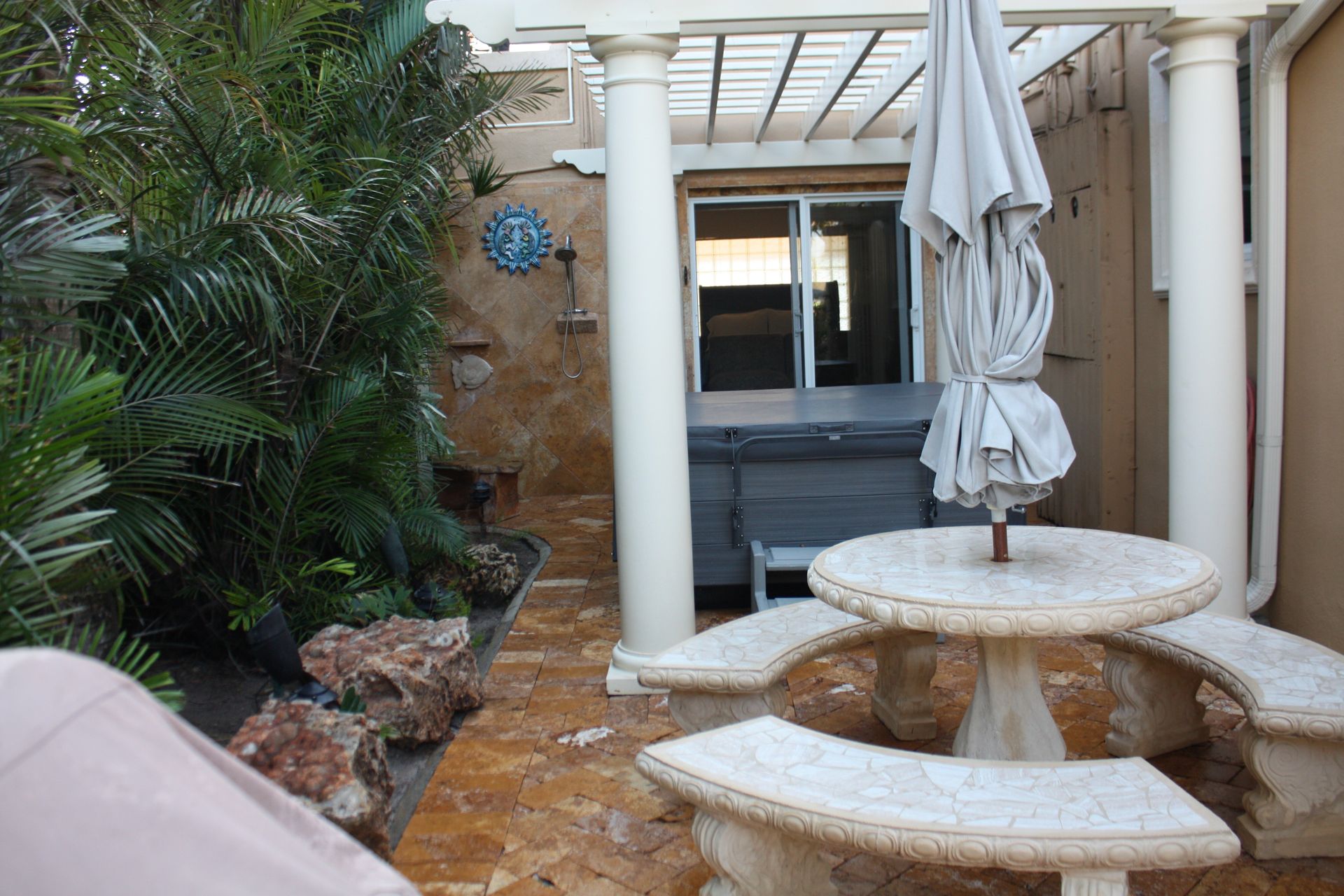 A patio area with a picnic table and umbrellas