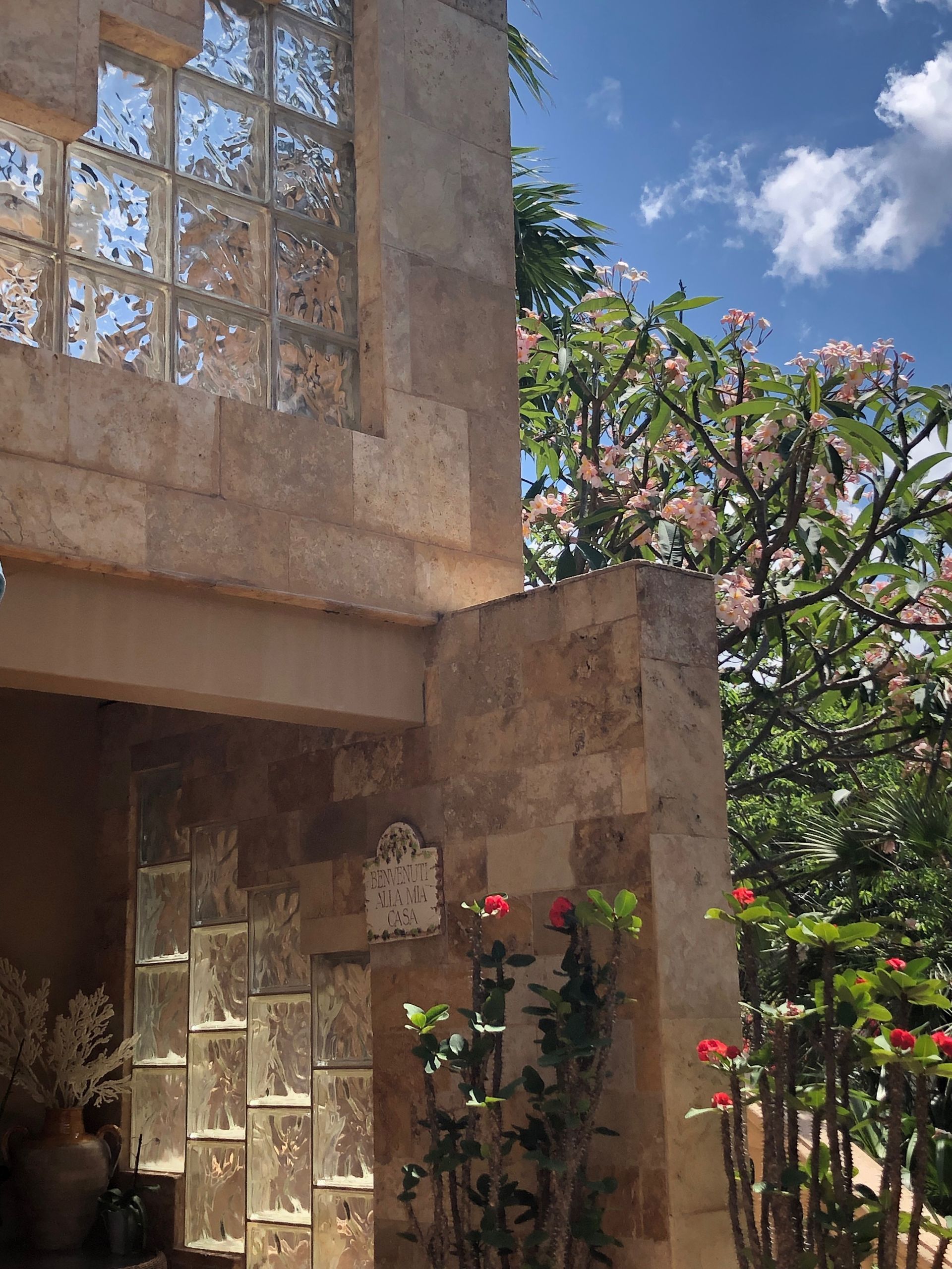 A building with a lot of windows and flowers in front of it.