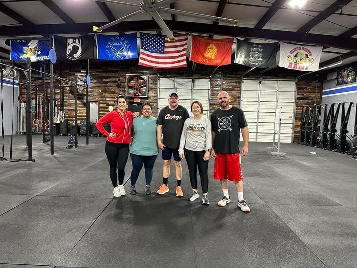 A group of people are posing for a picture in a gym.