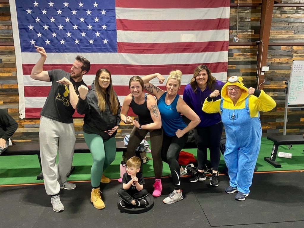 A group of people are posing for a picture in front of an american flag.