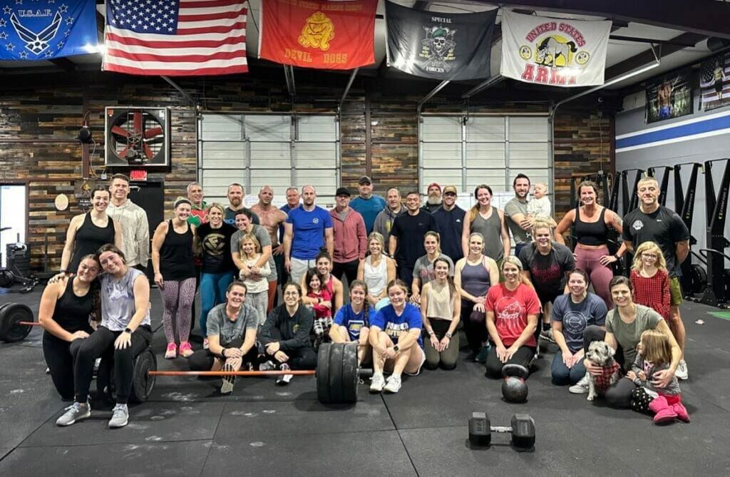A group of people are posing for a picture in a gym.