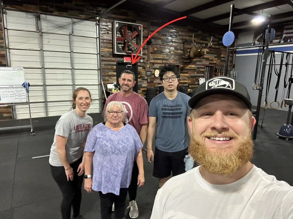 A group of people are posing for a picture in a gym.