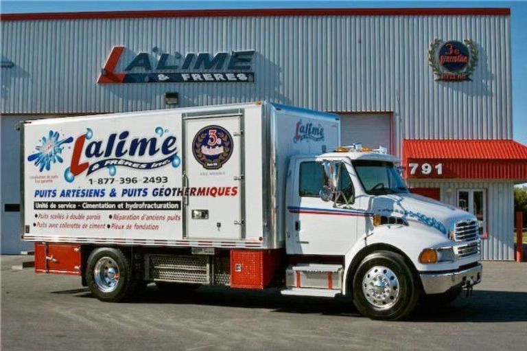 Camion de livraison blanc portant le logo « Lalime » stationné devant un bâtiment.