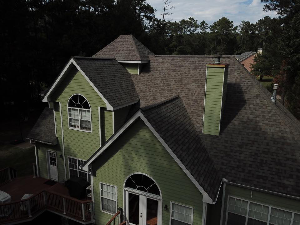 dark green painted house with dark roof that had repairs done by Total Roof Solutions in Georgia