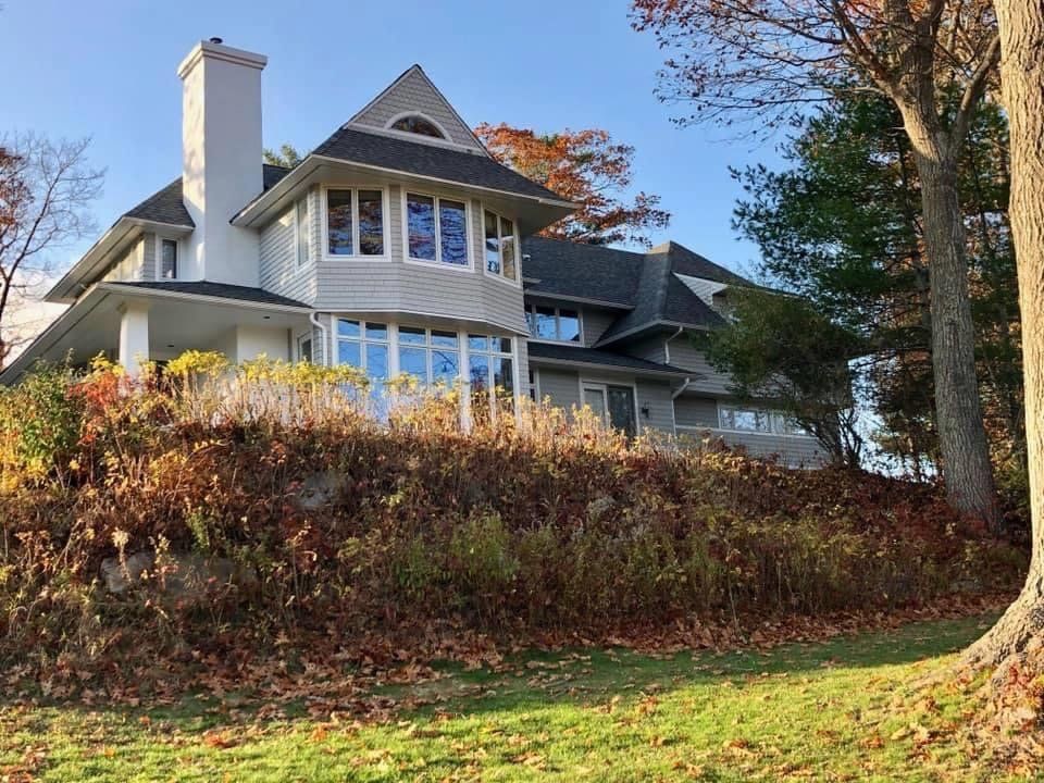 Red and orange bush in fall in front of windows on a home in Atlanta, GA