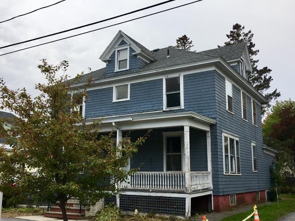 blue painted home  with white fenced porch worked on by Total Roof Solutions in Atlanta, GA