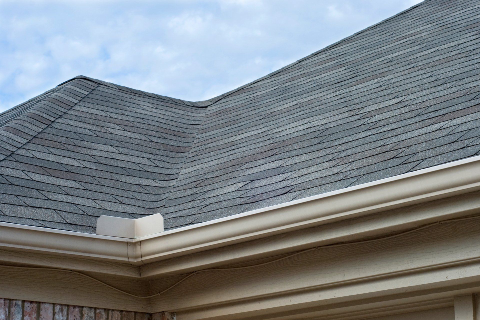 house with grey roof and seamless gutters