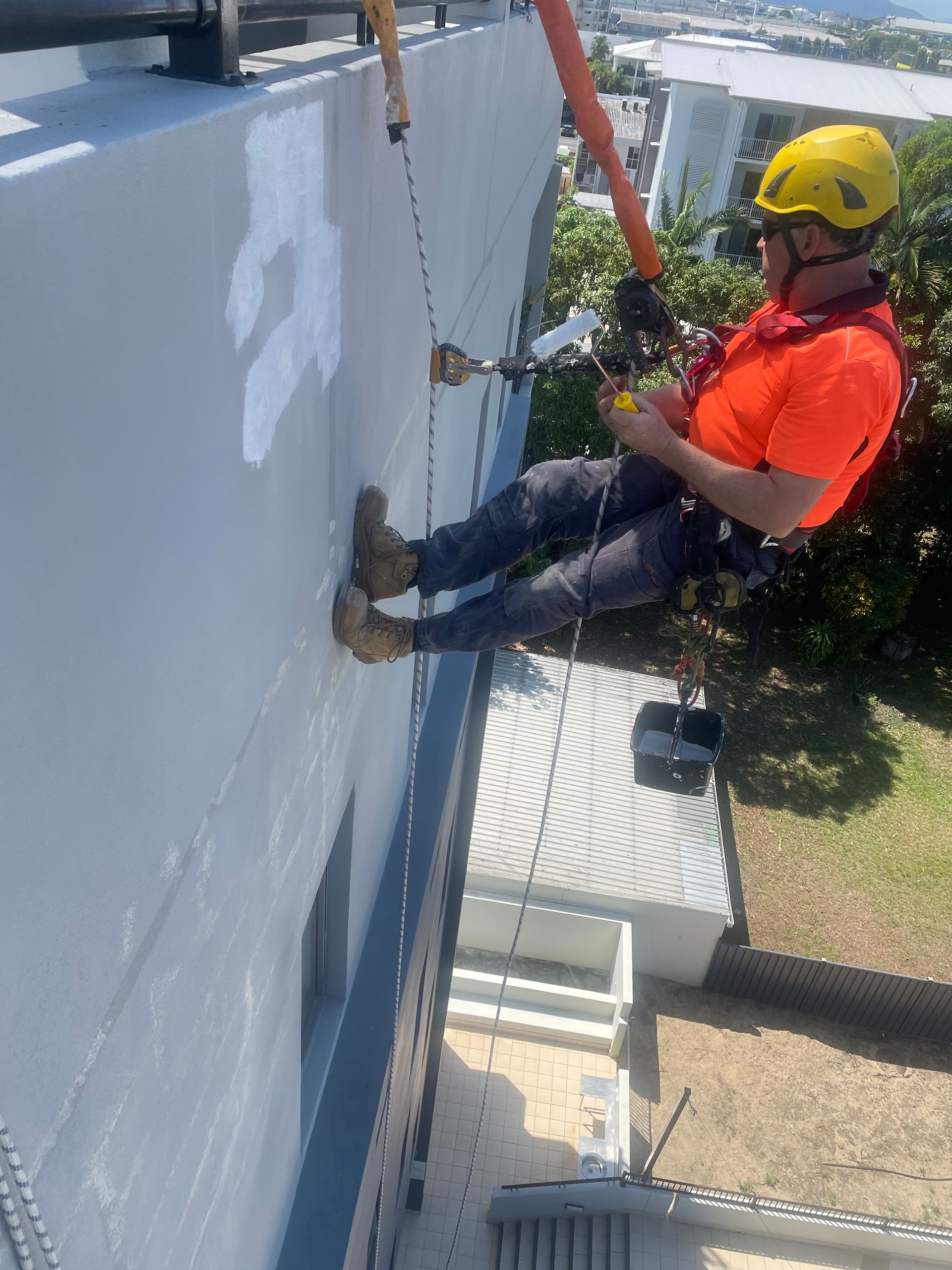 Construction Worker Painting a Dark Waterproof Coating — QBSA Waterproofing & Tile Injection in Portsmith, QLD