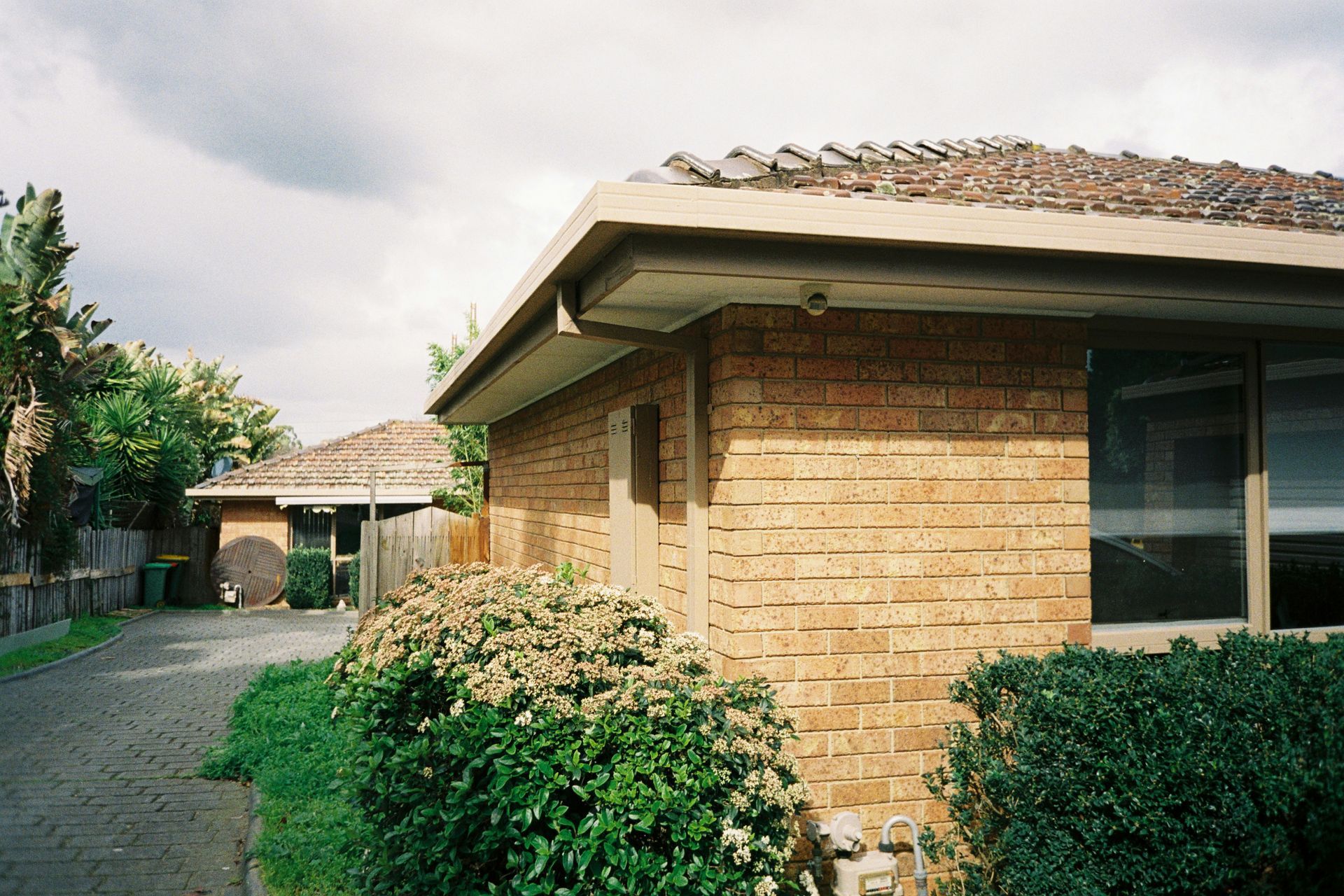 A brick house with a roof that is covered in shingles