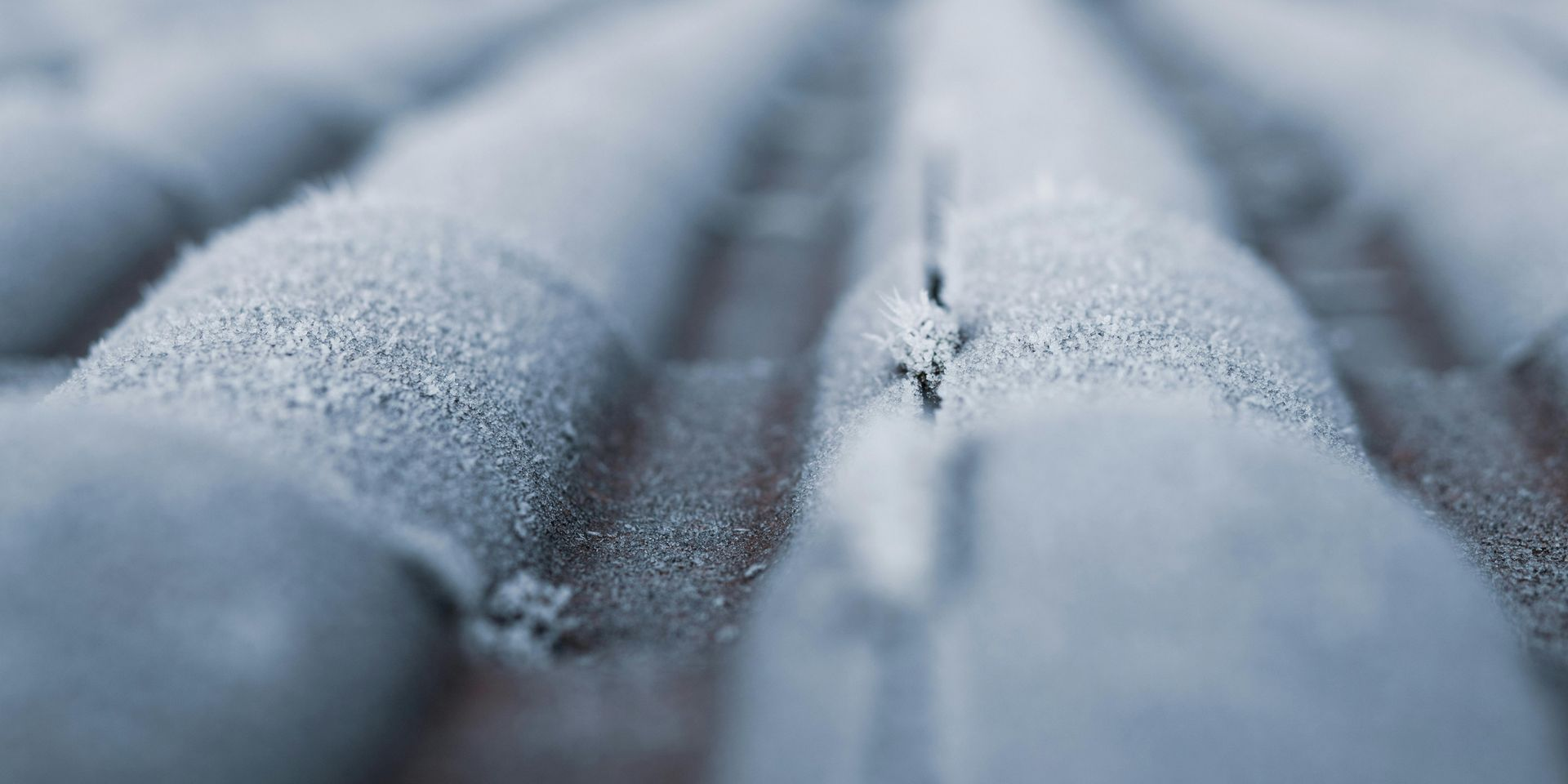 Close-up of a textured, wavy surface covered in a fine, granular substance, likely frost or snow.