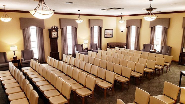 A large room with rows of chairs and a clock on the wall