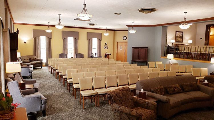 A large room with rows of chairs and a couch