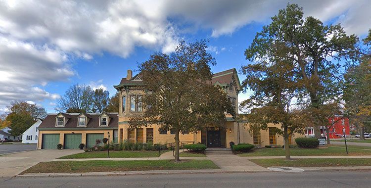 A large house with a lot of trees in front of it