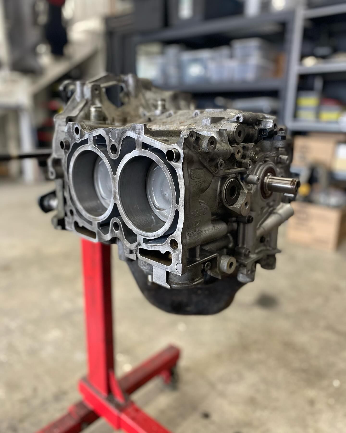 A close up of a car engine sitting on top of a red stand.